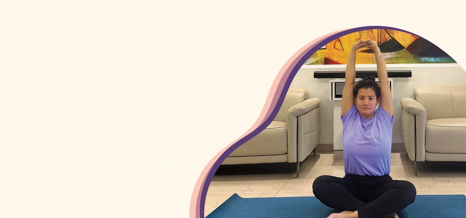 Woman seated in cross-legged position with arms raised overhead, practicing mindful stretching